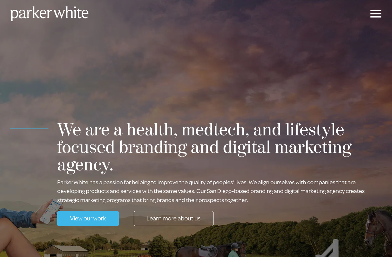 ```json
{
  "alt": "ParkerWhite branding and digital marketing agency homepage featuring their focus on health, medtech, and lifestyle.",
  "caption": "Dive into a world where branding meets innovation. Discover ParkerWhite's unique approach to health, medtech, and lifestyle marketing.",
  "description": "This image showcases the homepage of ParkerWhite, a branding and digital marketing agency emphasizing health, medtech, and lifestyle sectors. A serene evening sky forms the backdrop, enhancing the agency’s message. The text outlines ParkerWhite's commitment to improving quality through strategic partnerships. The visual elements and call-to-action buttons encourage exploration of their work and values."
}
```