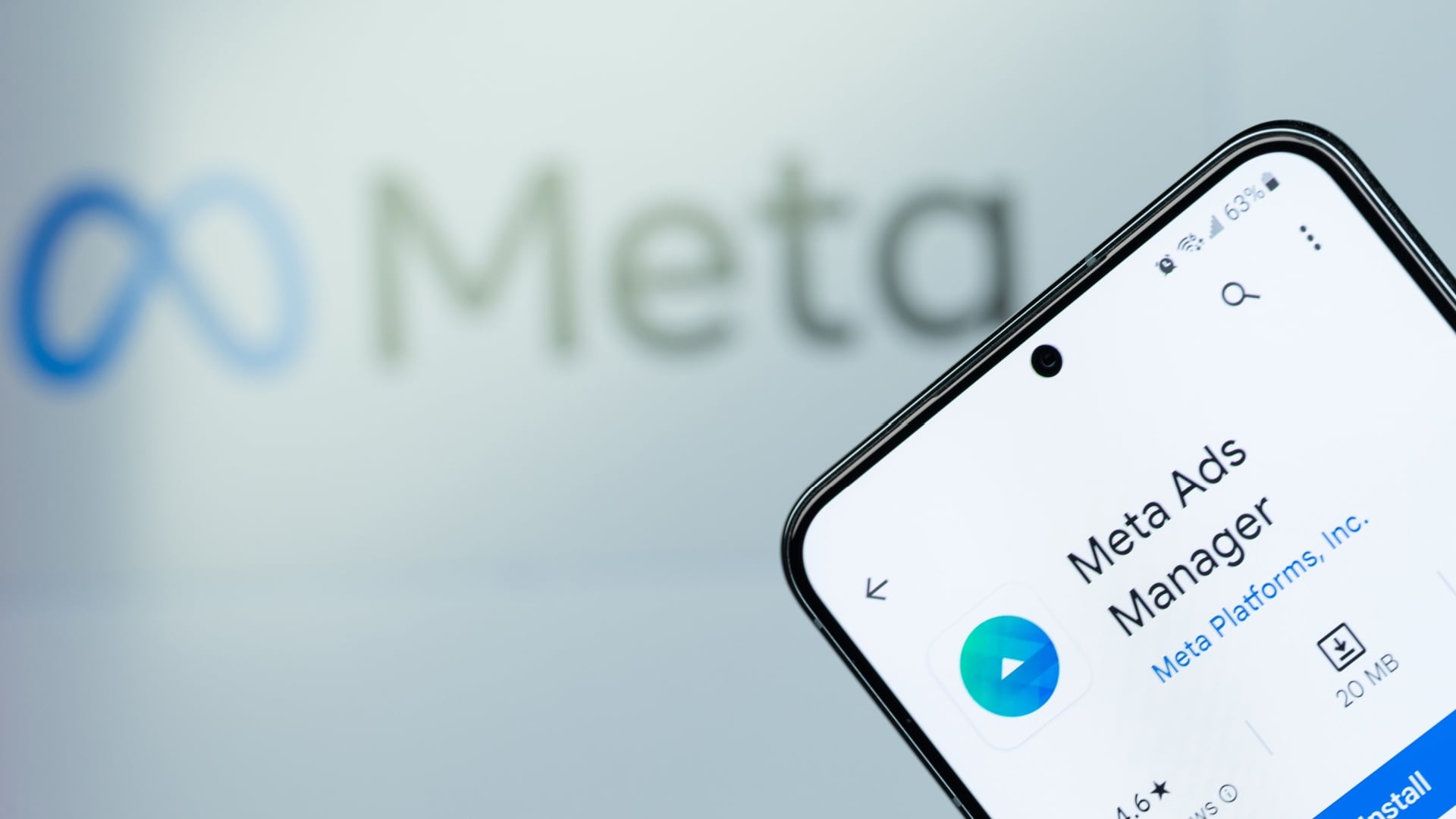 ```json
{
"alt": "Smartphone displaying Meta Ads Manager app with blurred Meta logo in background.",
"caption": "Explore the Meta Ads Manager for seamless advertising solutions, now available for installation on your mobile device.",
"description": "This image features a smartphone screen displaying the Meta Ads Manager app, ready for installation with a file size of 20 MB. The blurred Meta logo appears in the background, symbolizing the connection to Meta Platforms. The app has a 4.6-star rating, indicating positive user feedback. This setup highlights Meta's focus on digital advertising solutions through accessible mobile technology, catering to businesses and marketers."
}
```