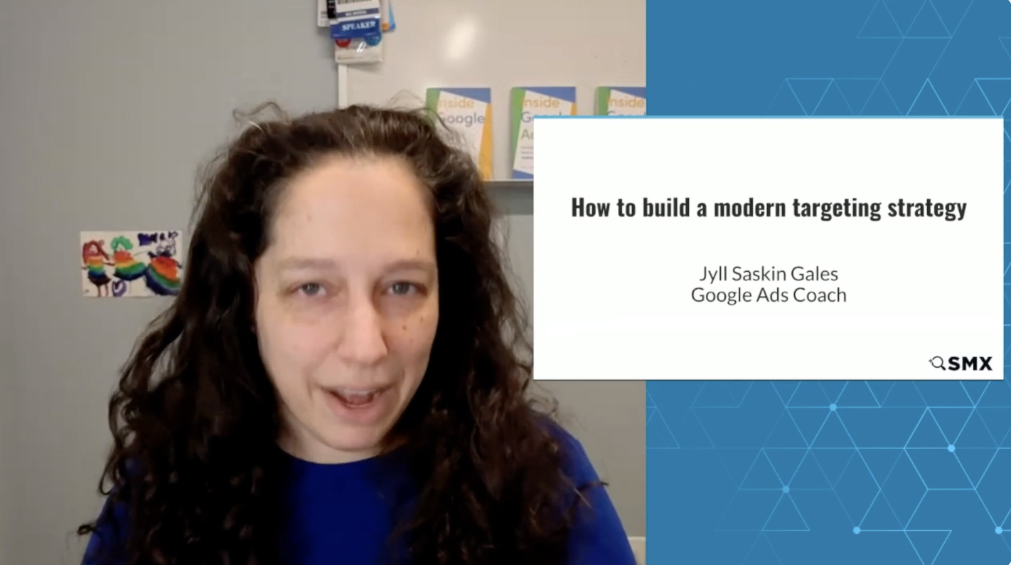 ```json
{
  "alt": "Person speaking during an online presentation titled 'How to build a modern targeting strategy.'",
  "caption": "Unlock the secrets of modern targeting strategies with insights from a Google Ads Coach during this engaging online presentation.",
  "description": "The image shows a presenter delivering an online talk titled 'How to build a modern targeting strategy.' The speaker is positioned on the left, with the presentation slide on the right. The slide includes the name Jyll Saskin Gales and title Google Ads Coach, with an SMX logo at the bottom. The setting appears to be a personal office, with colorful wall decor and books visible in the background. Keywords: online presentation, Google Ads, targeting strategy, digital marketing."
}
```