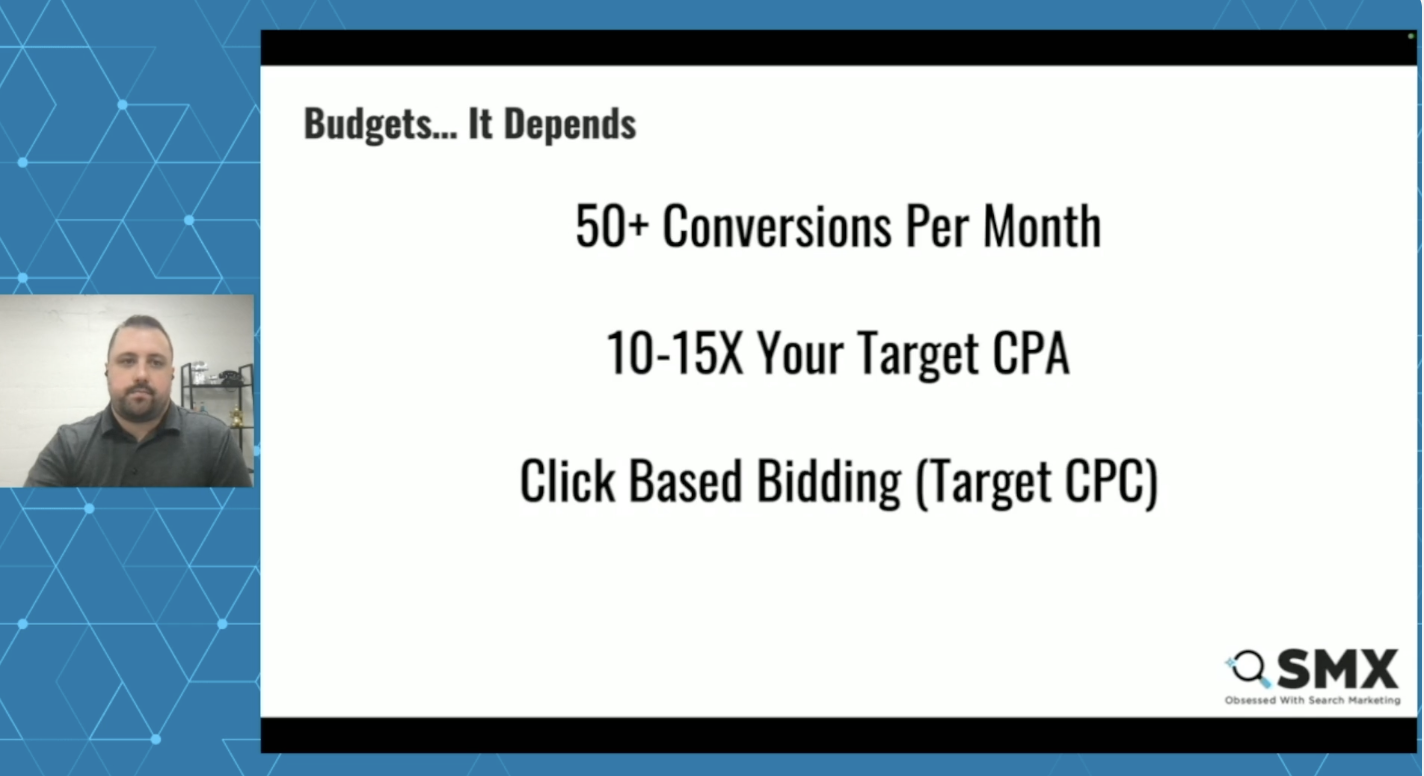 ```json
{
  "alt": "Presentation slide with guidelines for budgeting conversions per month and bidding strategies.",
  "caption": "Explore effective budgeting strategies with guidelines on monthly conversions and bidding techniques in this insightful presentation.",
  "description": "This presentation slide discusses budgeting strategies, highlighting the need for over 50 conversions per month and recommending a budget of 10-15 times the target CPA. It suggests click-based bidding (target CPC) as a strategy. The slide is part of an SMX presentation, illustrated with geometric patterns alongside the speaker's image, adding a professional touch to the analysis of digital marketing practices."
}
```
