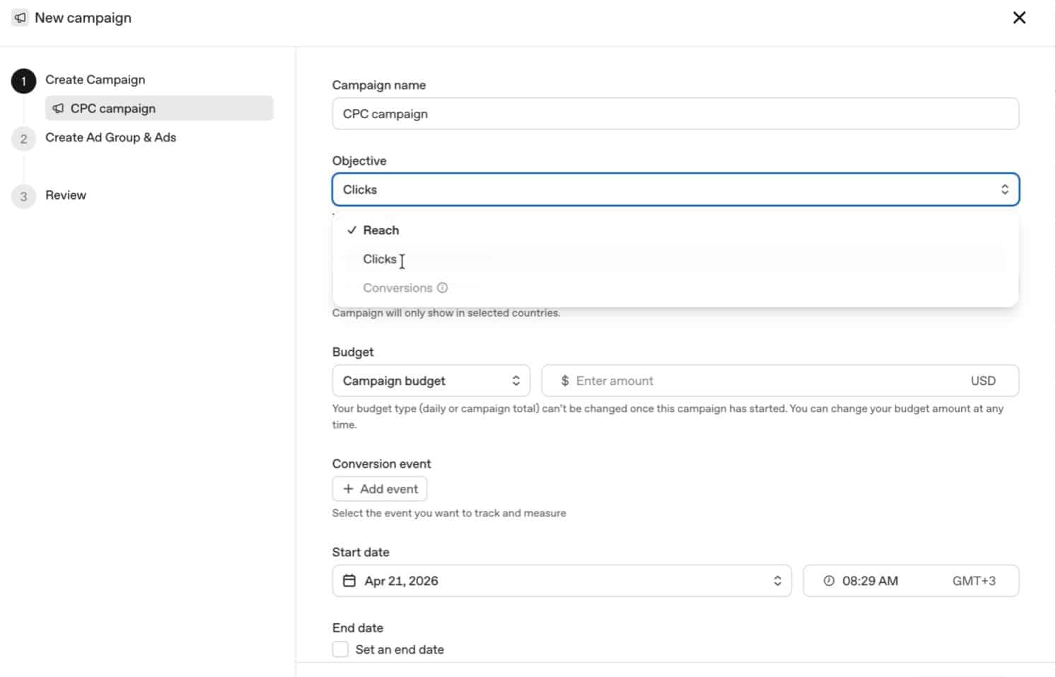 ```json
{
  "alt": "Screenshot of a new campaign setup page showing options for campaign name, objective, budget, and start date.",
  "caption": "Setting up your CPC campaign has never been easier! Choose your campaign's objective, budget, and launch date all in one streamlined interface.",
  "description": "This image displays a screenshot of a new campaign setup interface for creating a CPC campaign. Users can enter a campaign name, select an objective such as 'Clicks', set a campaign budget in USD, define a conversion event, and choose start and end dates. The interface is user-friendly, designed to guide users through campaign creation in three steps: Create Campaign, Create Ad Group & Ads, and Review. Keywords: campaign setup, CPC campaign, marketing, digital advertising."
}
```