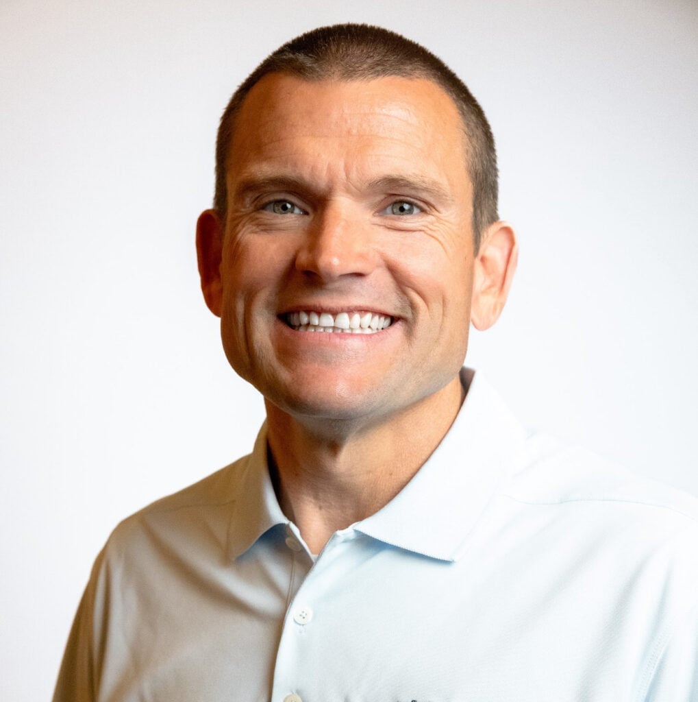 ```json
{
  "alt": "Smiling man in a light-colored polo shirt against a plain background.",
  "caption": "A person radiates positivity, showcasing a broad smile and friendly demeanor in a light-colored shirt.",
  "description": "The image features a man with a beaming smile wearing a light-colored polo shirt. The plain background draws focus to his cheerful expression, creating an inviting and positive atmosphere. Ideal for profiles or promotional content emphasizing friendliness and approachability."
}
```