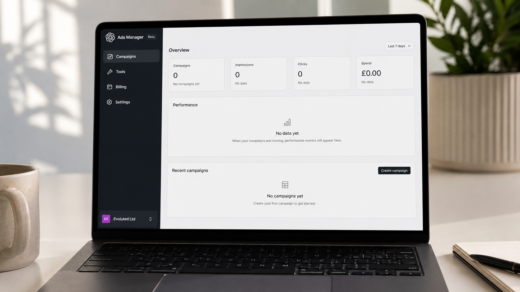 ```json
{
  "alt": "Laptop displaying an ads manager interface with no active campaigns, set on a desk alongside a mug and notebook.",
  "caption": "Starting fresh with the Ads Manager! Ready to launch campaigns and track your performance metrics efficiently.",
  "description": "The image showcases a laptop on a desk featuring an ads manager interface in beta mode. The screen shows no active campaigns or data, inviting users to create a campaign. Accompanying the laptop, a ceramic mug and a notebook are on the desk, adding a touch of aesthetics. The interface includes sections for campaigns, tools, billing, and settings, making it easy to manage advertising efforts. The image evokes a sense of readiness and opportunity to start digital marketing ventures."
}
```